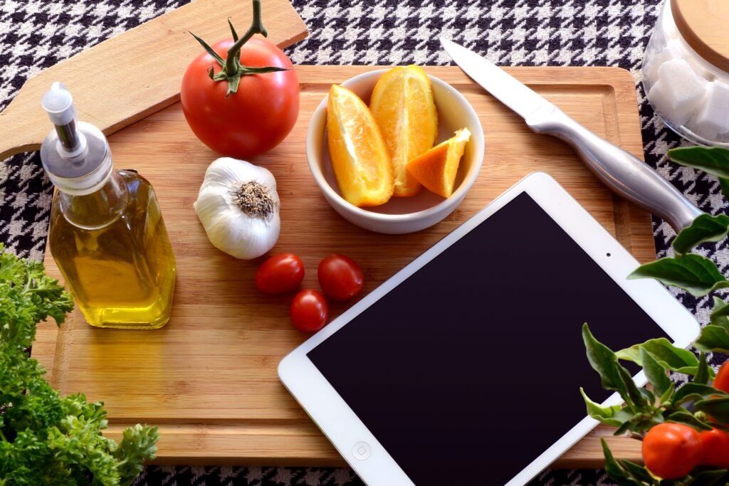 Top view of fresh ingredients and a tablet on a cutting board, perfect for a cooking theme.